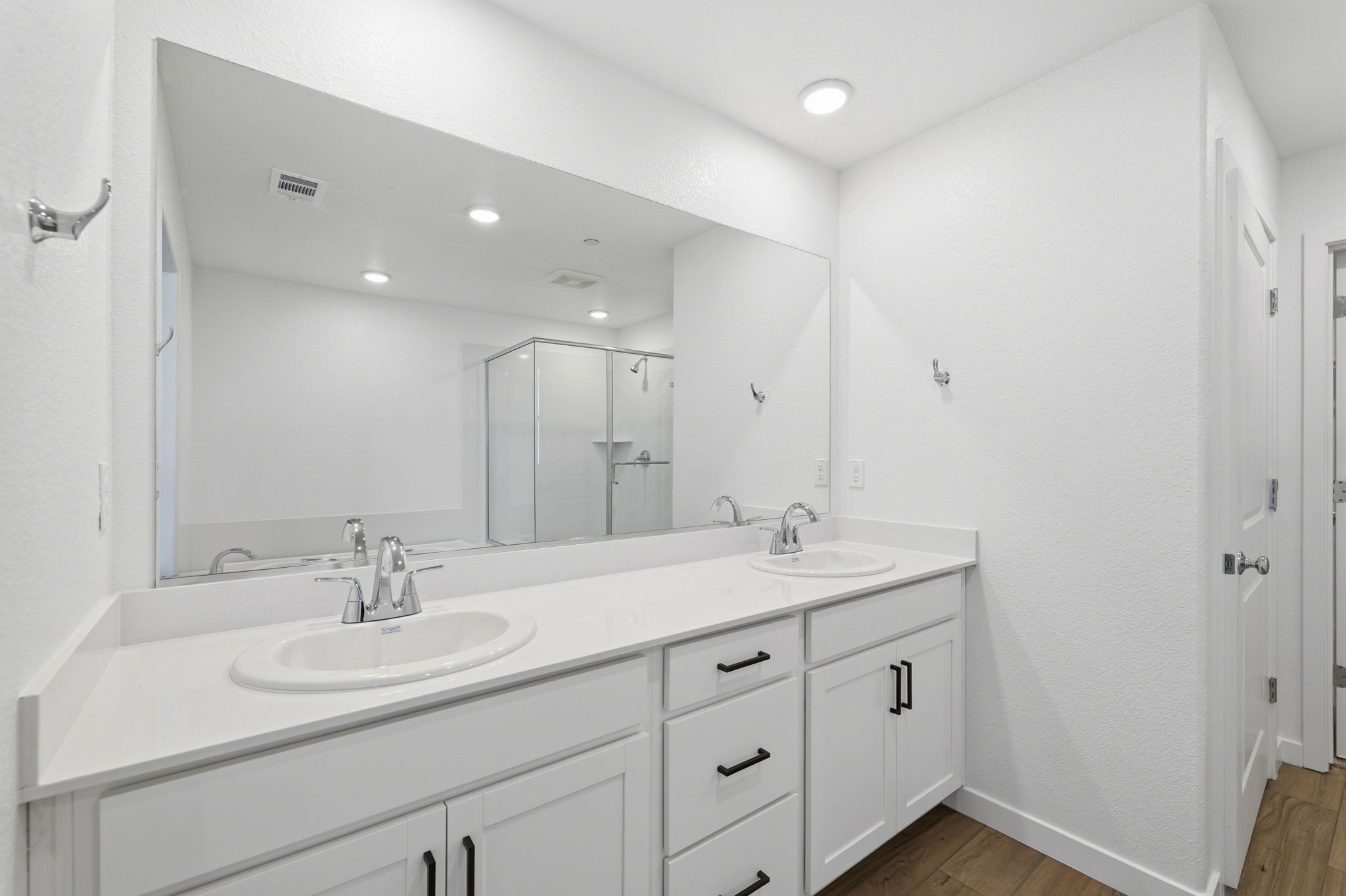 A bathroom with white cabinets.