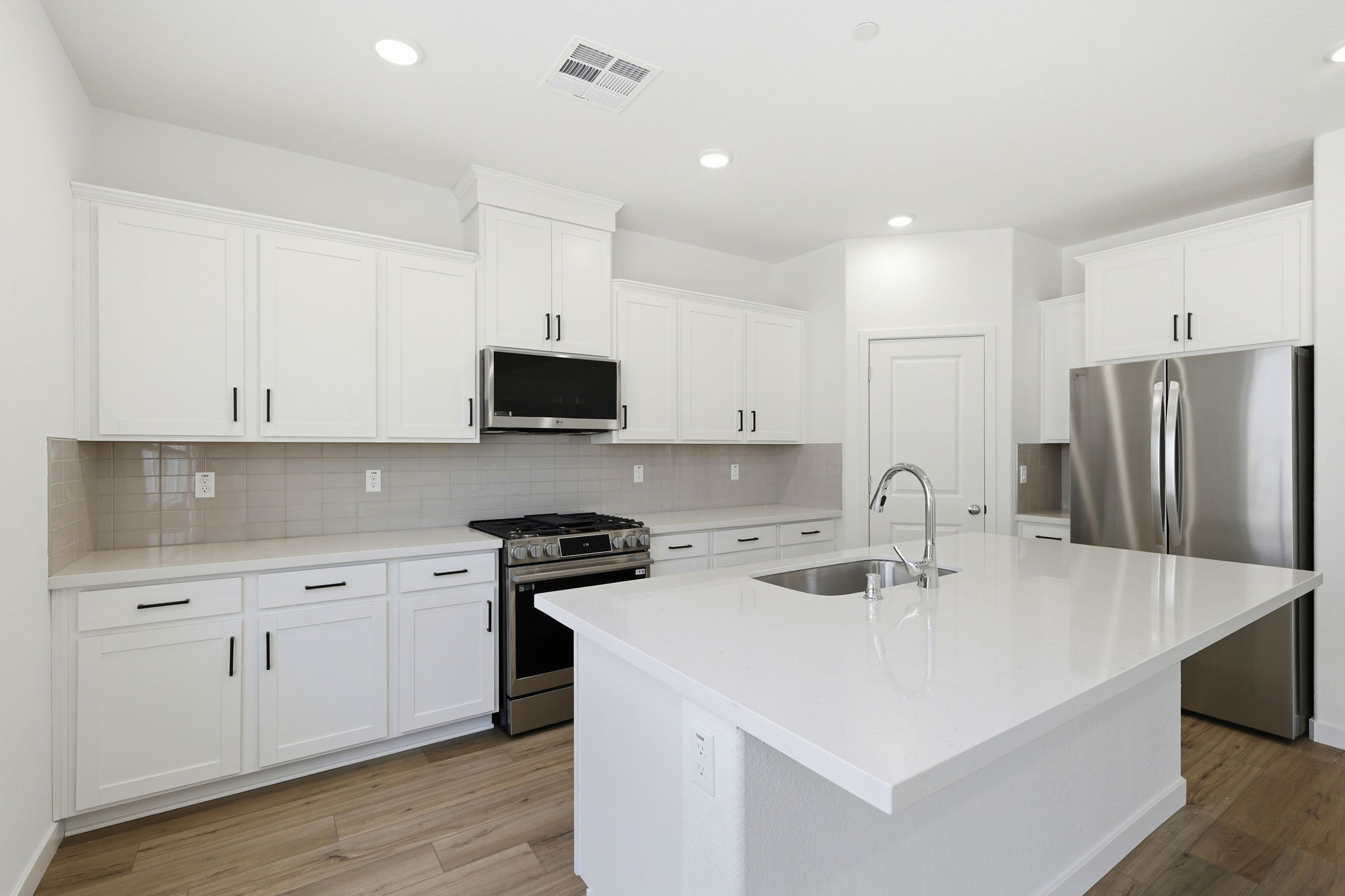 A kitchen with white cabinets.