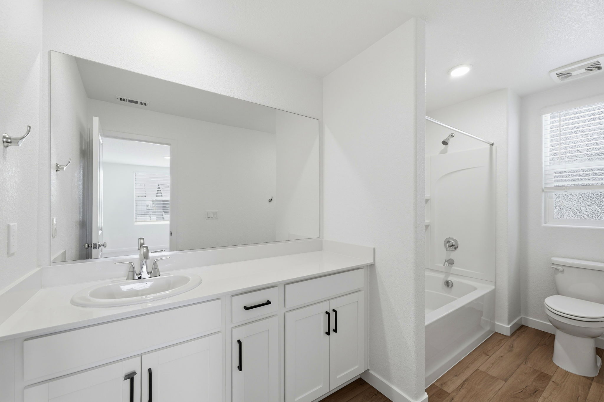 A bathroom with a tub sink and toilet.