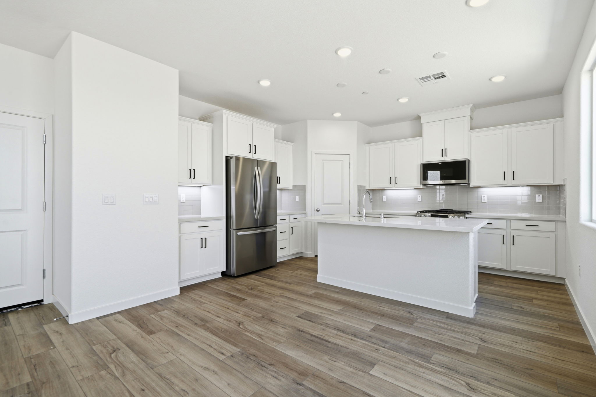 A kitchen with white cabinets.