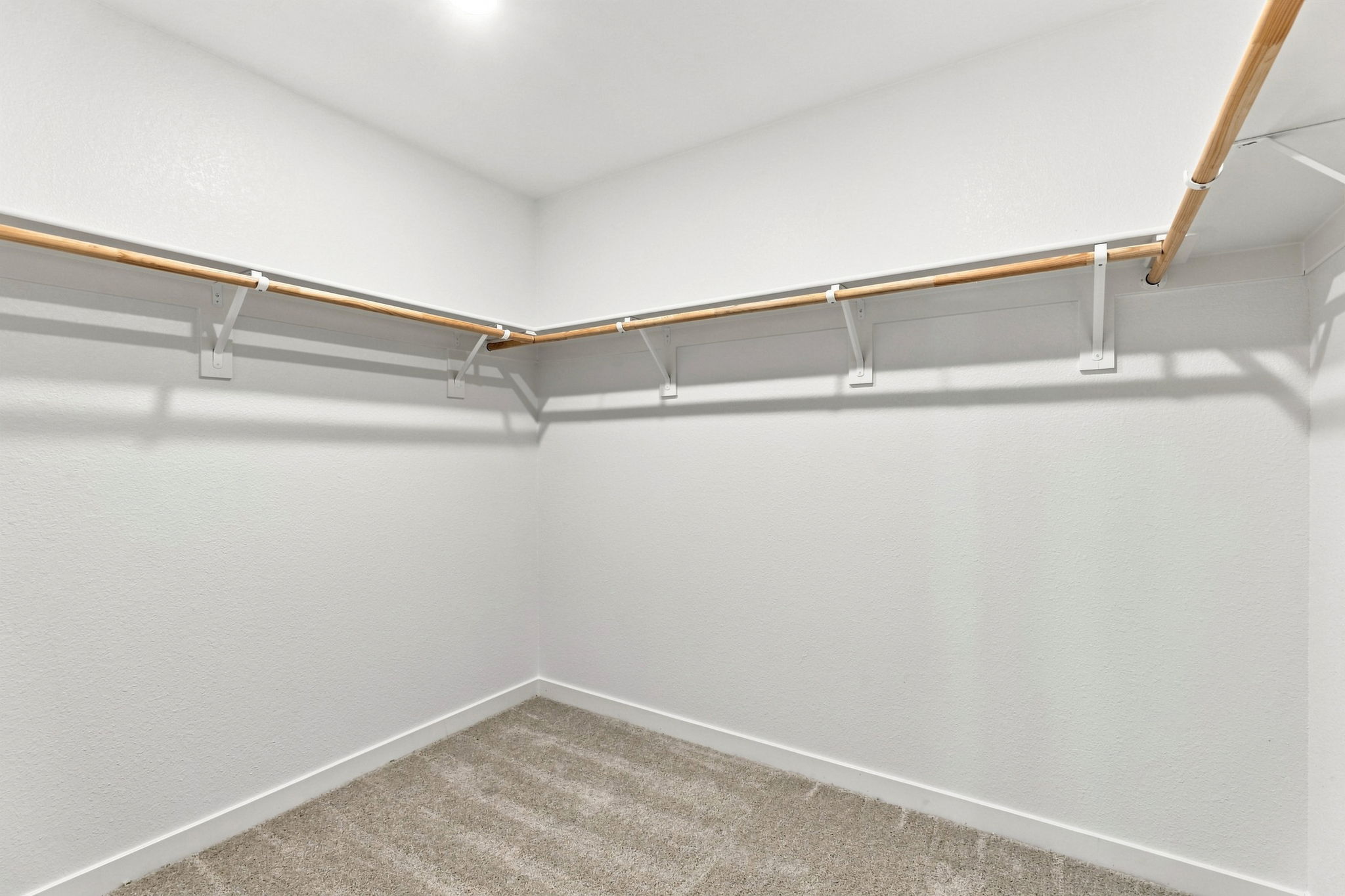 A white wall with a metal bar.