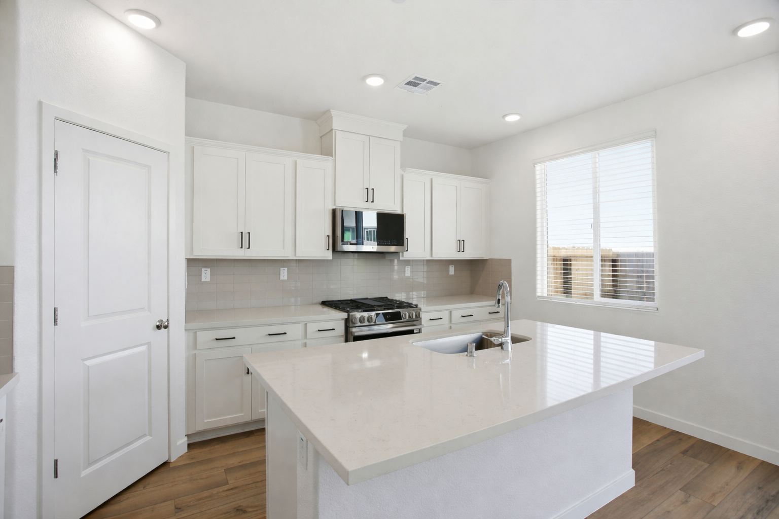 A kitchen with white cabinets.