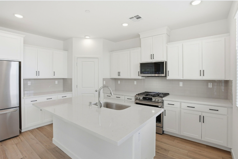 A kitchen with white cabinets.