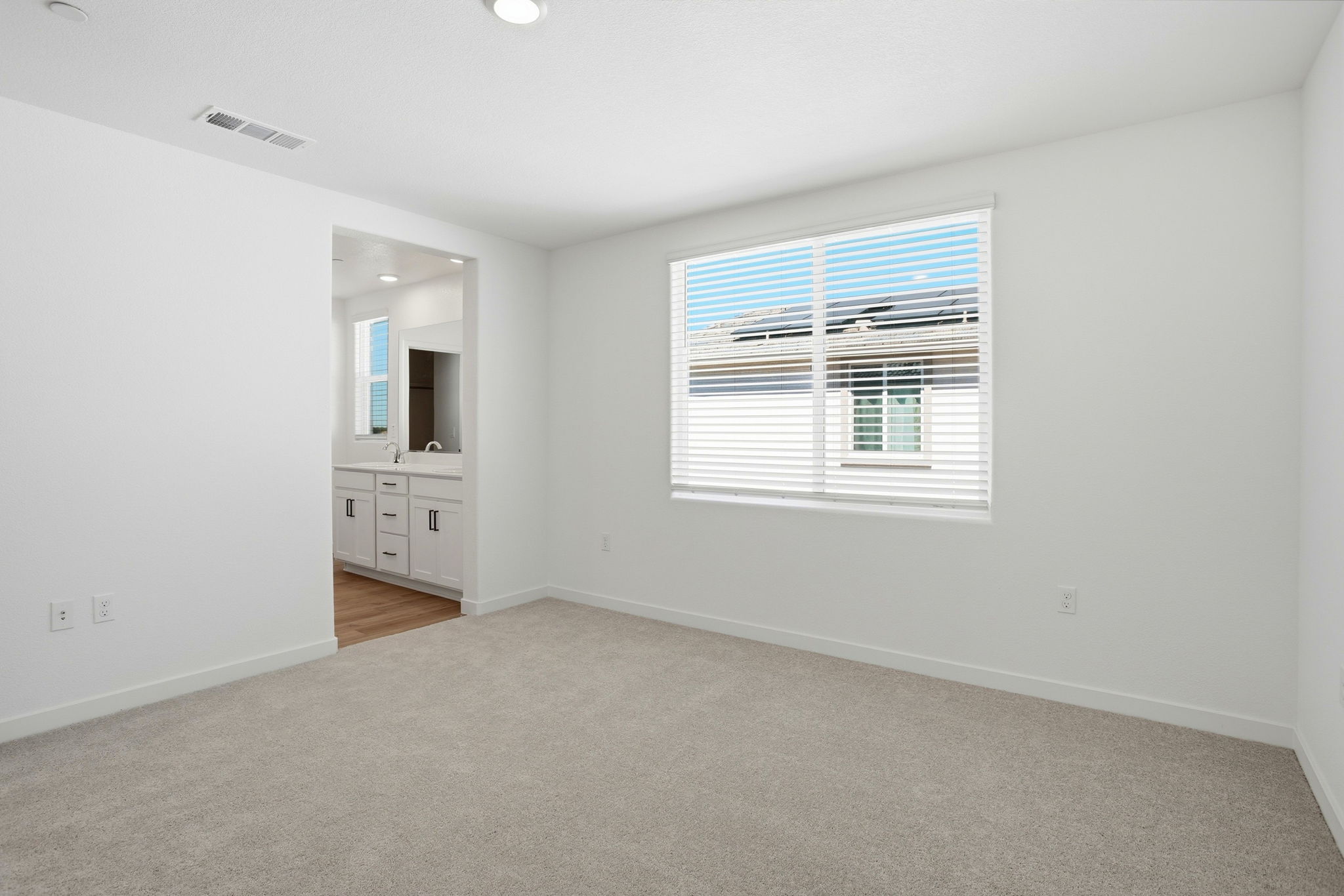 A room with a window and a white wall.