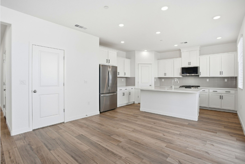 A kitchen with white cabinets.