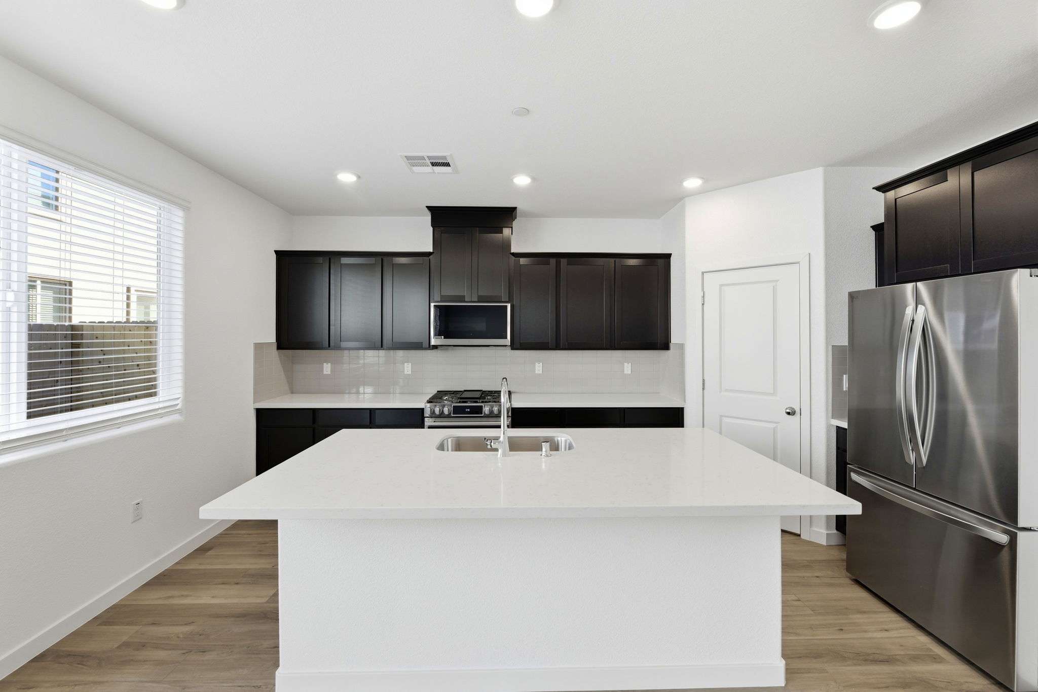 A kitchen with black cabinets.