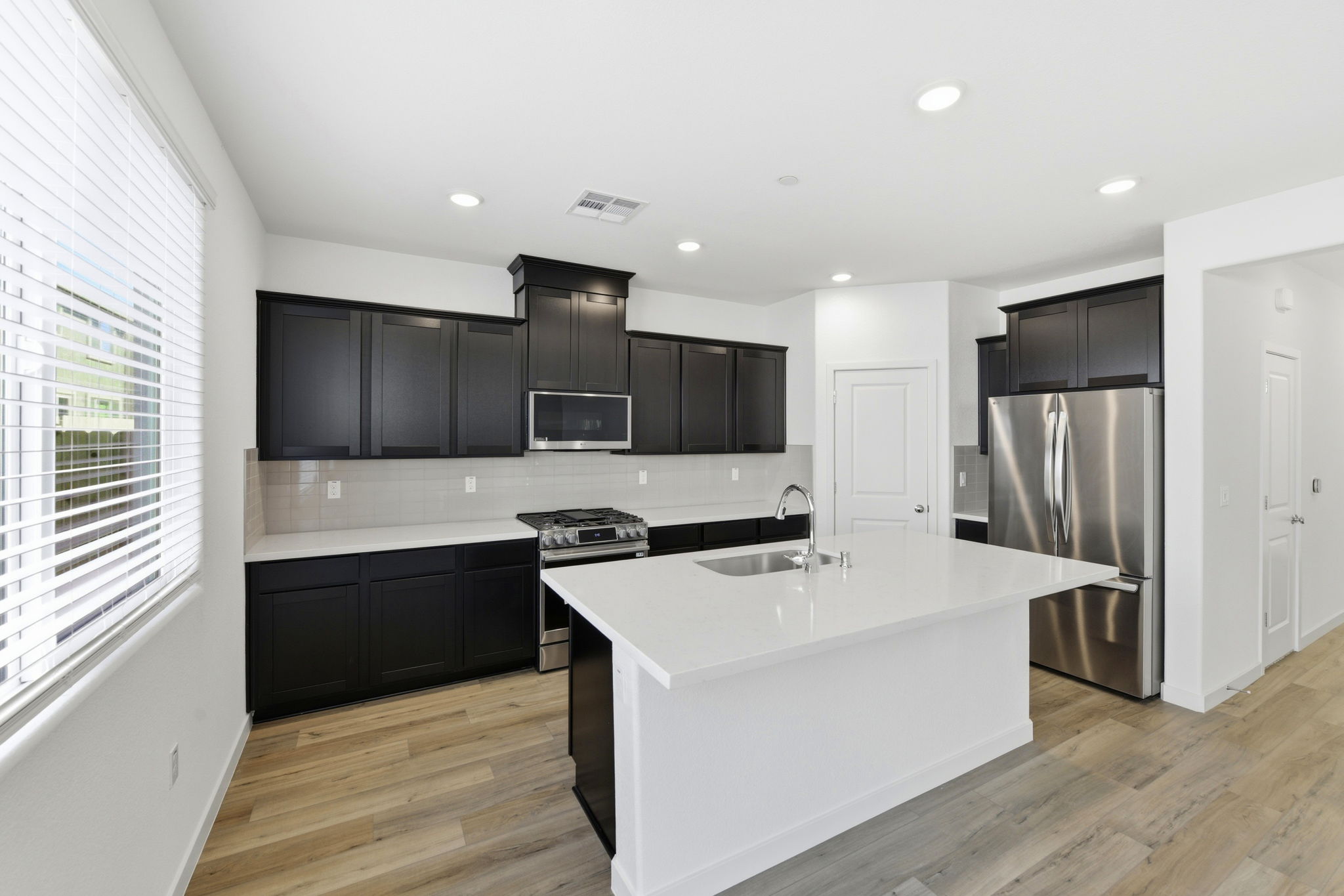 A kitchen with black cabinets.