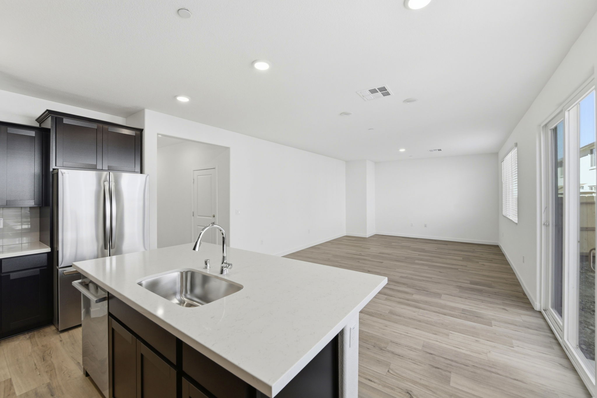A kitchen with a sink and a refrigerator.