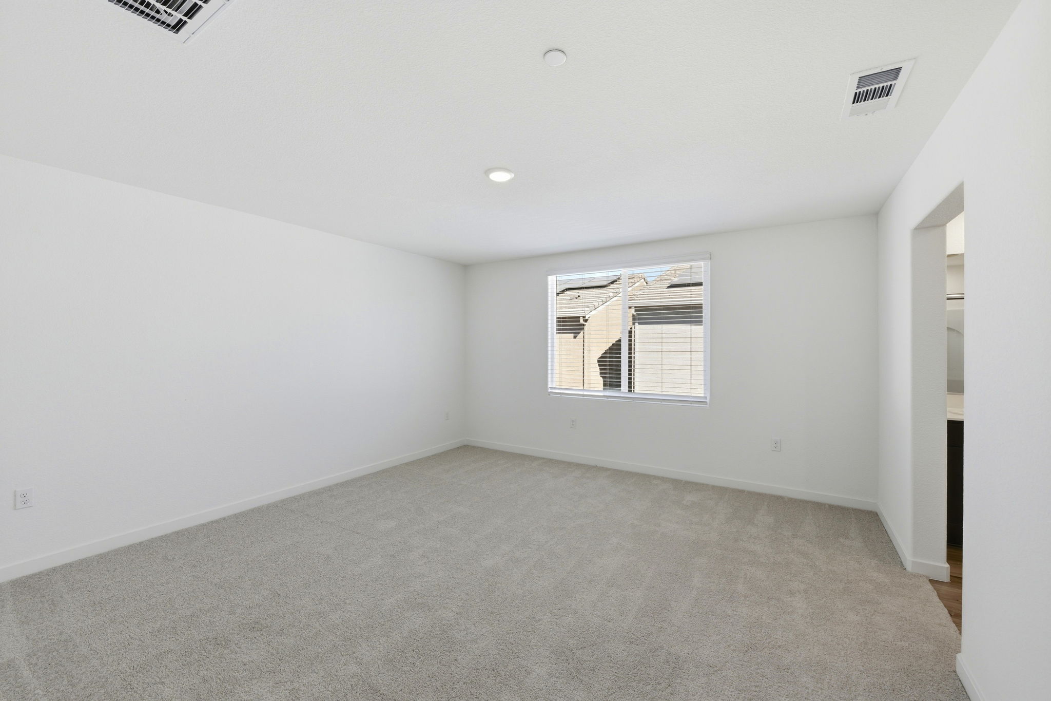 A room with a window and a carpet.