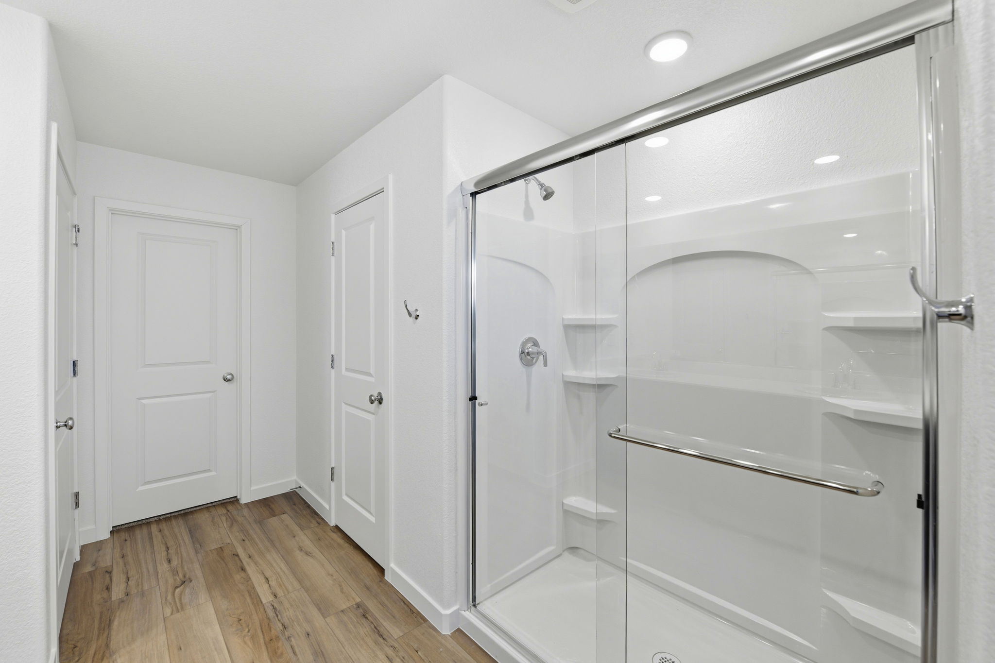 A white bathroom with a glass shower.