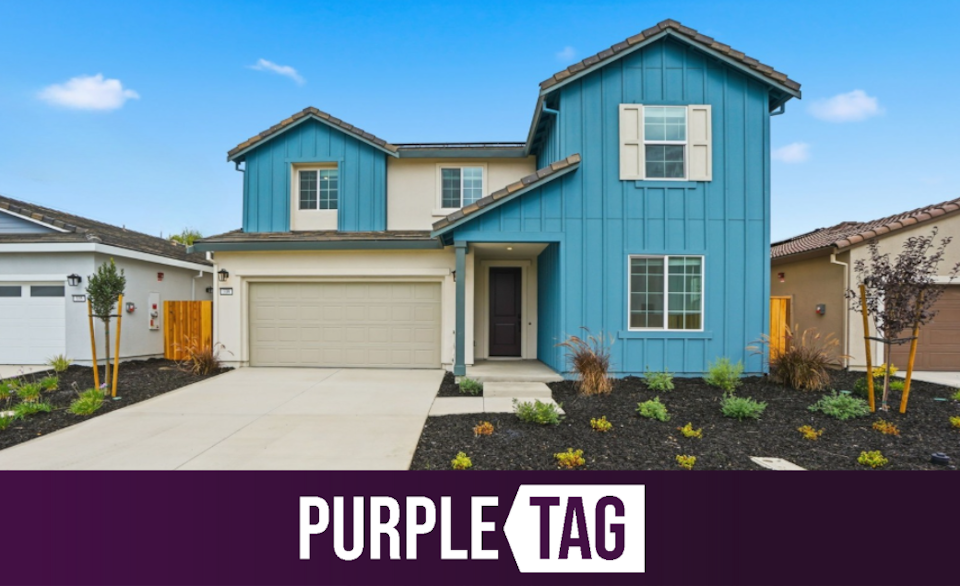 A blue house with a driveway.