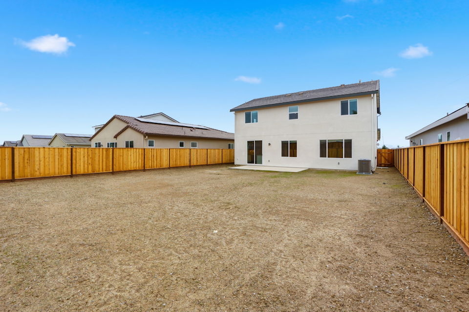 A dirt field with buildings in the background.