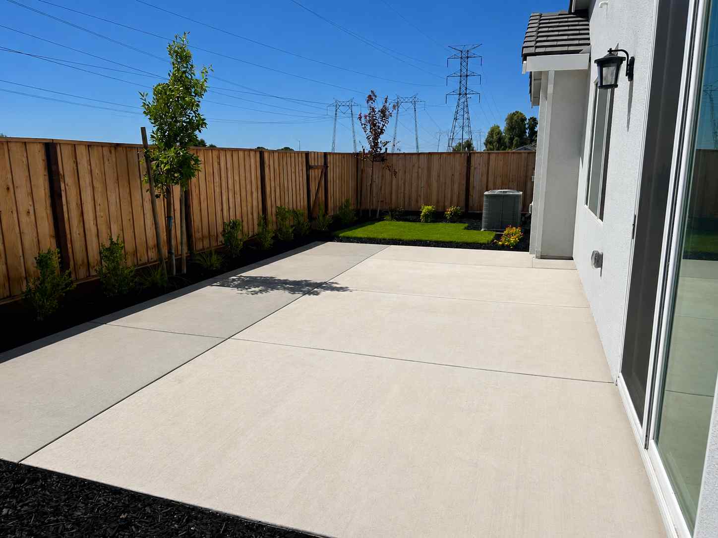 A driveway with a fence and a wood fence.