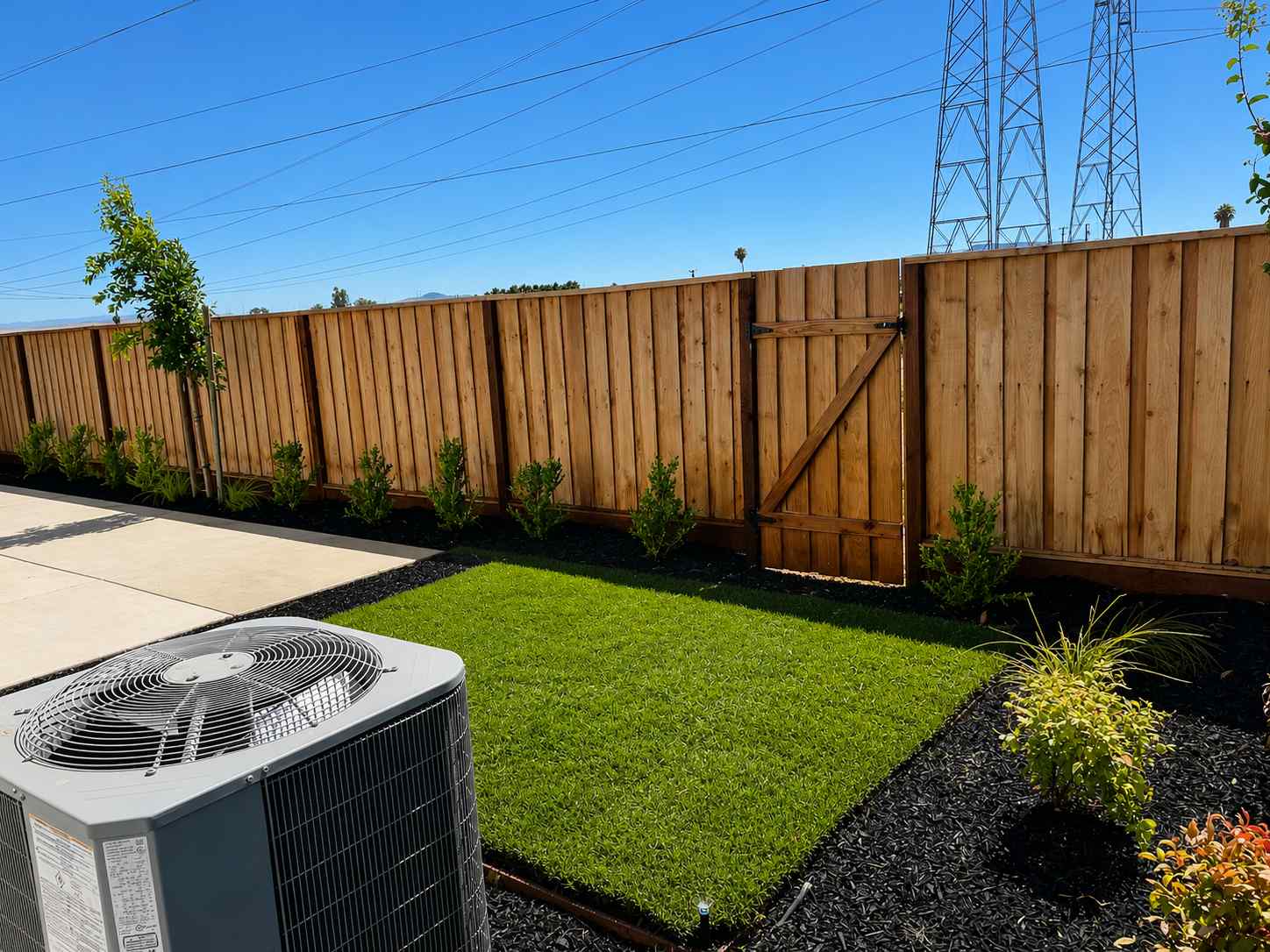 A backyard with a fence and a brick wall.