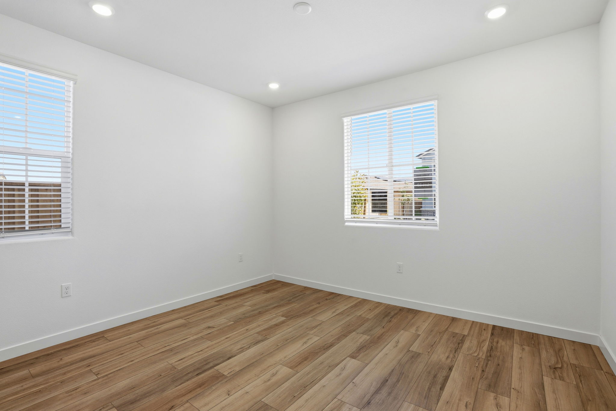 A room with a wood floor and windows.