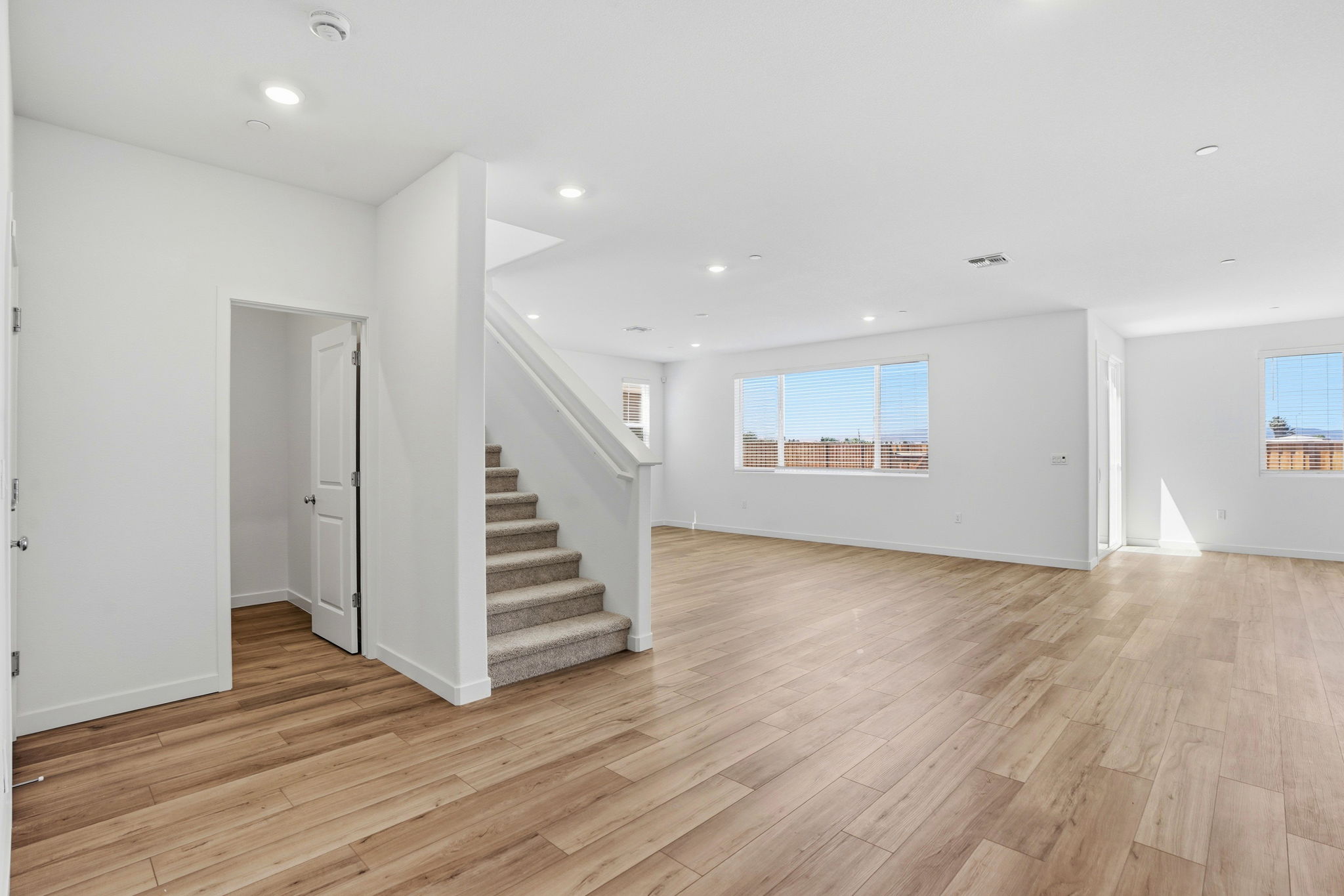 A large empty room with a wood floor and white walls.