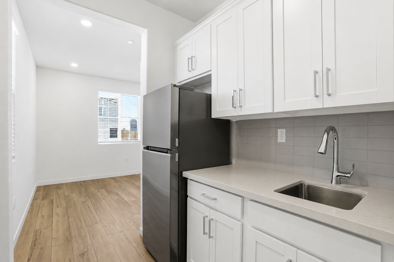 A kitchen with white cabinets.