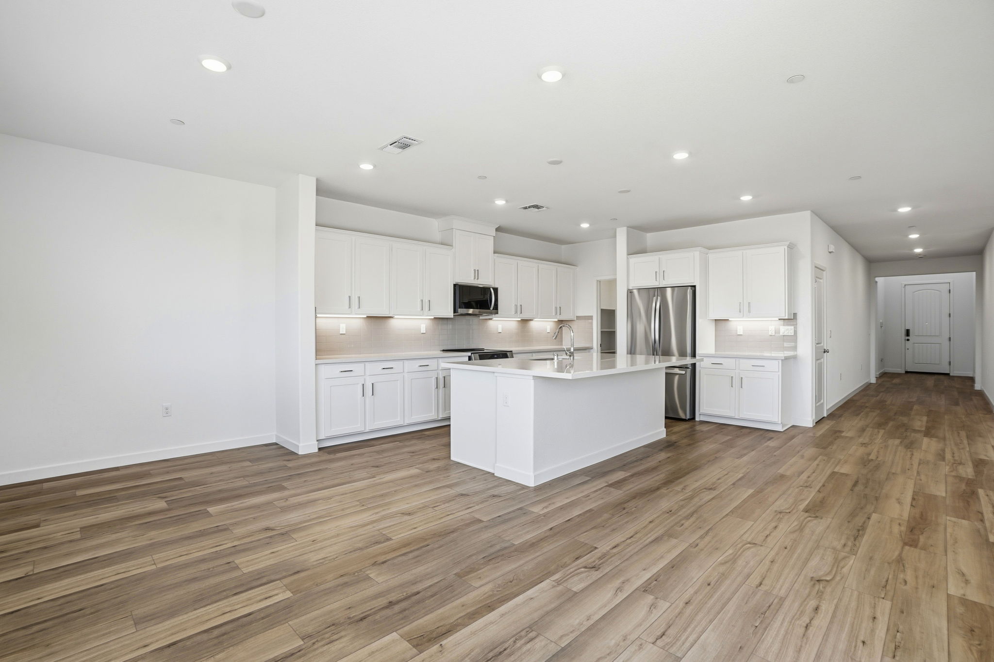 A kitchen with white cabinets.