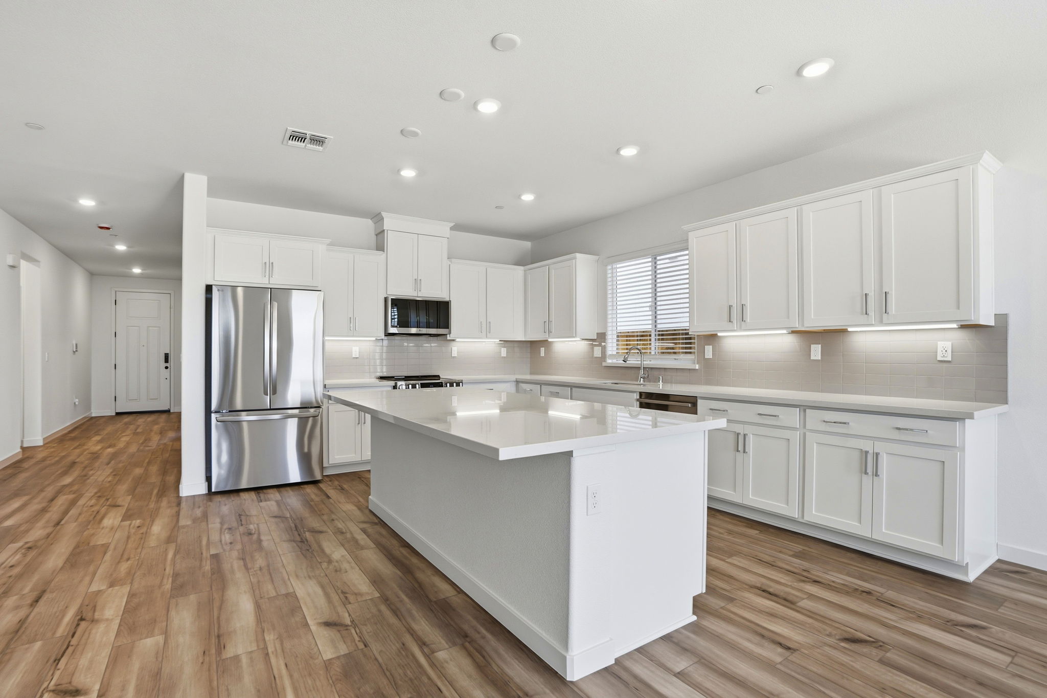 A kitchen with white cabinets.
