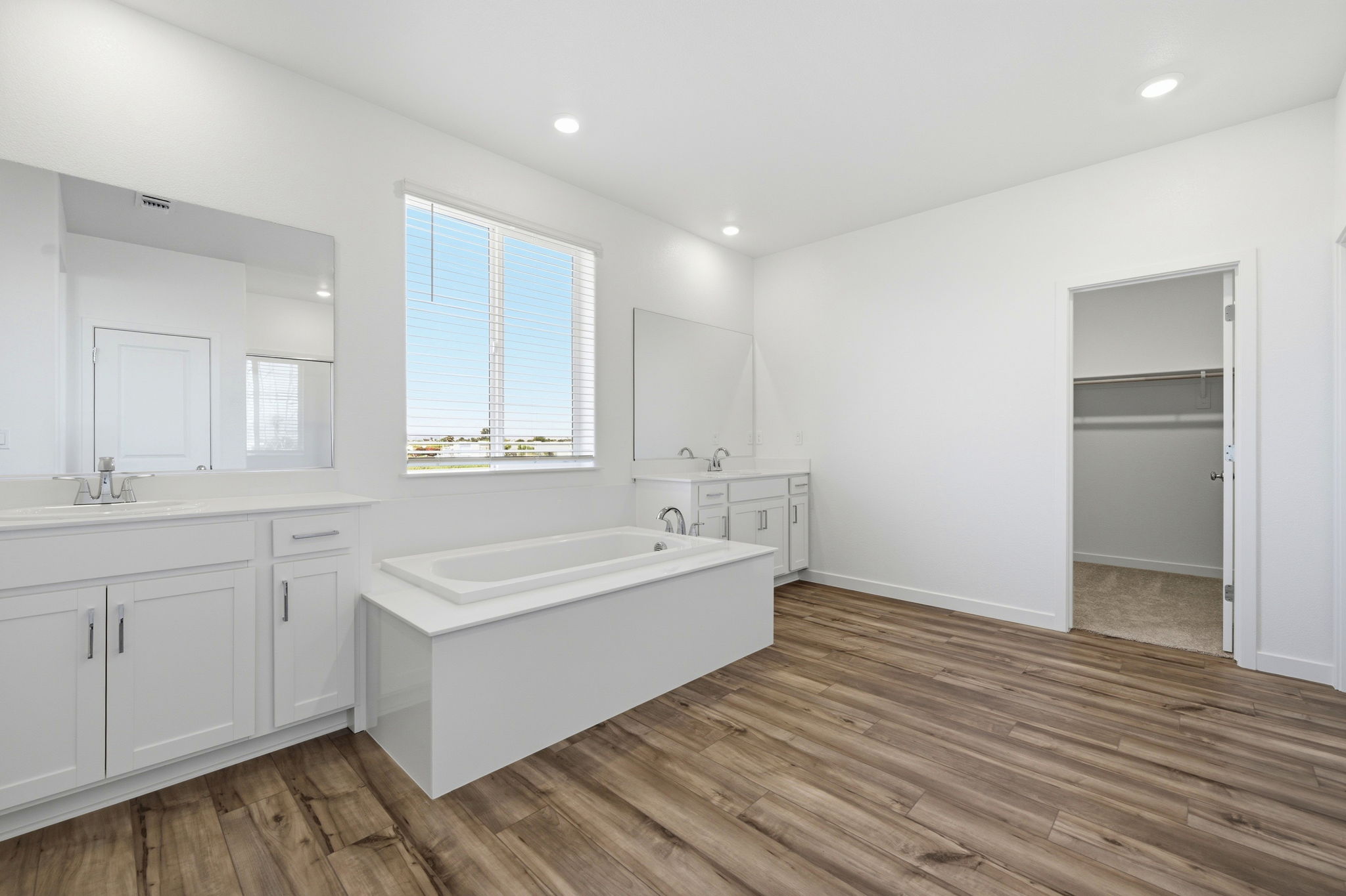 A bathroom with white cabinets.