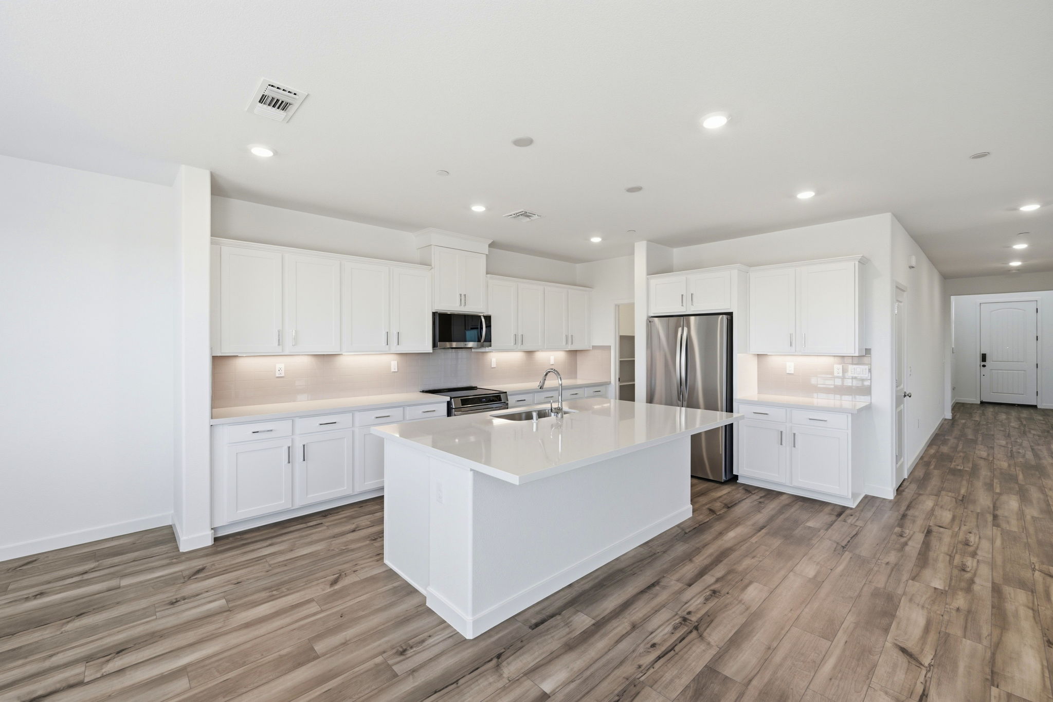 A kitchen with white cabinets.
