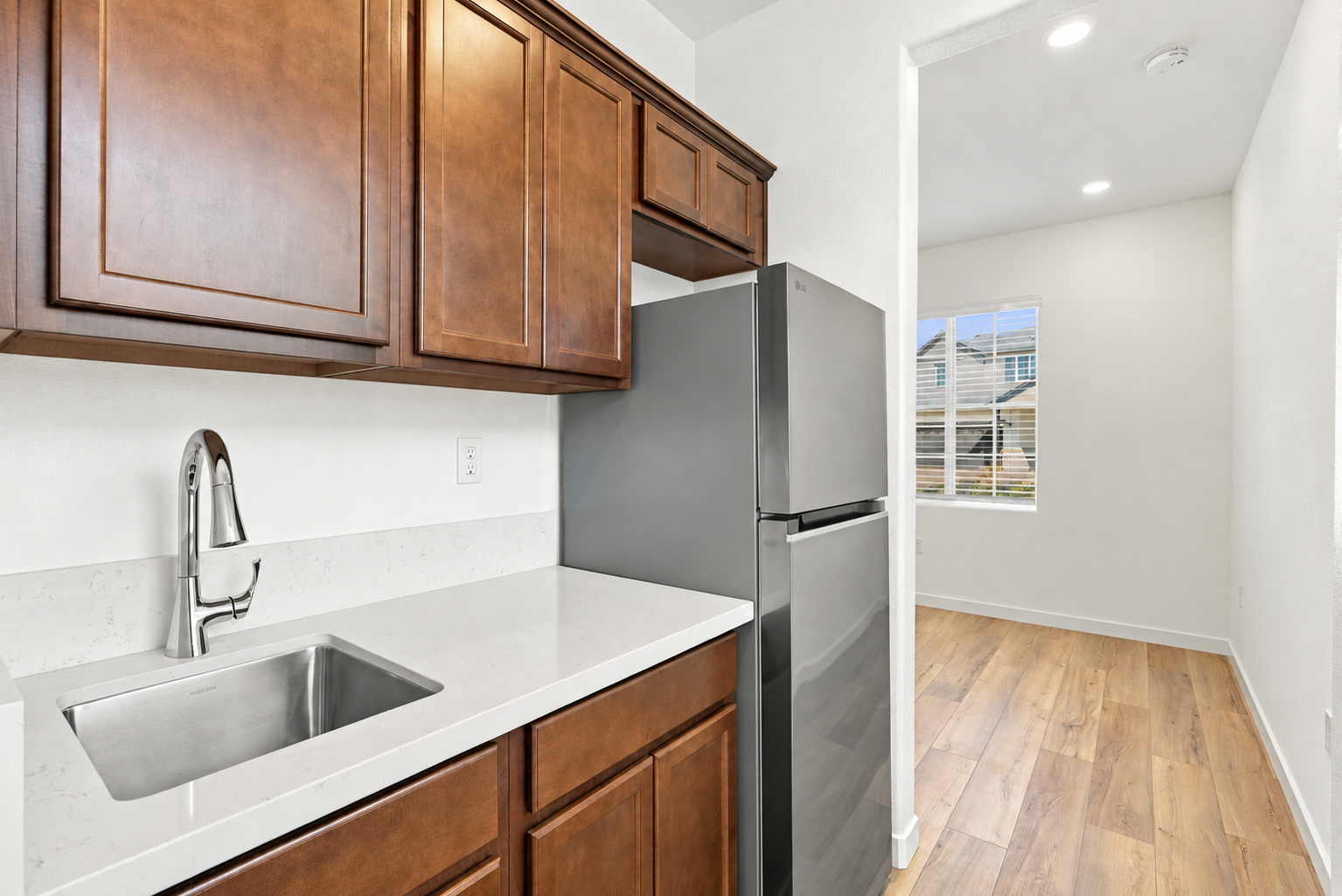 A kitchen with a stainless steel refrigerator.