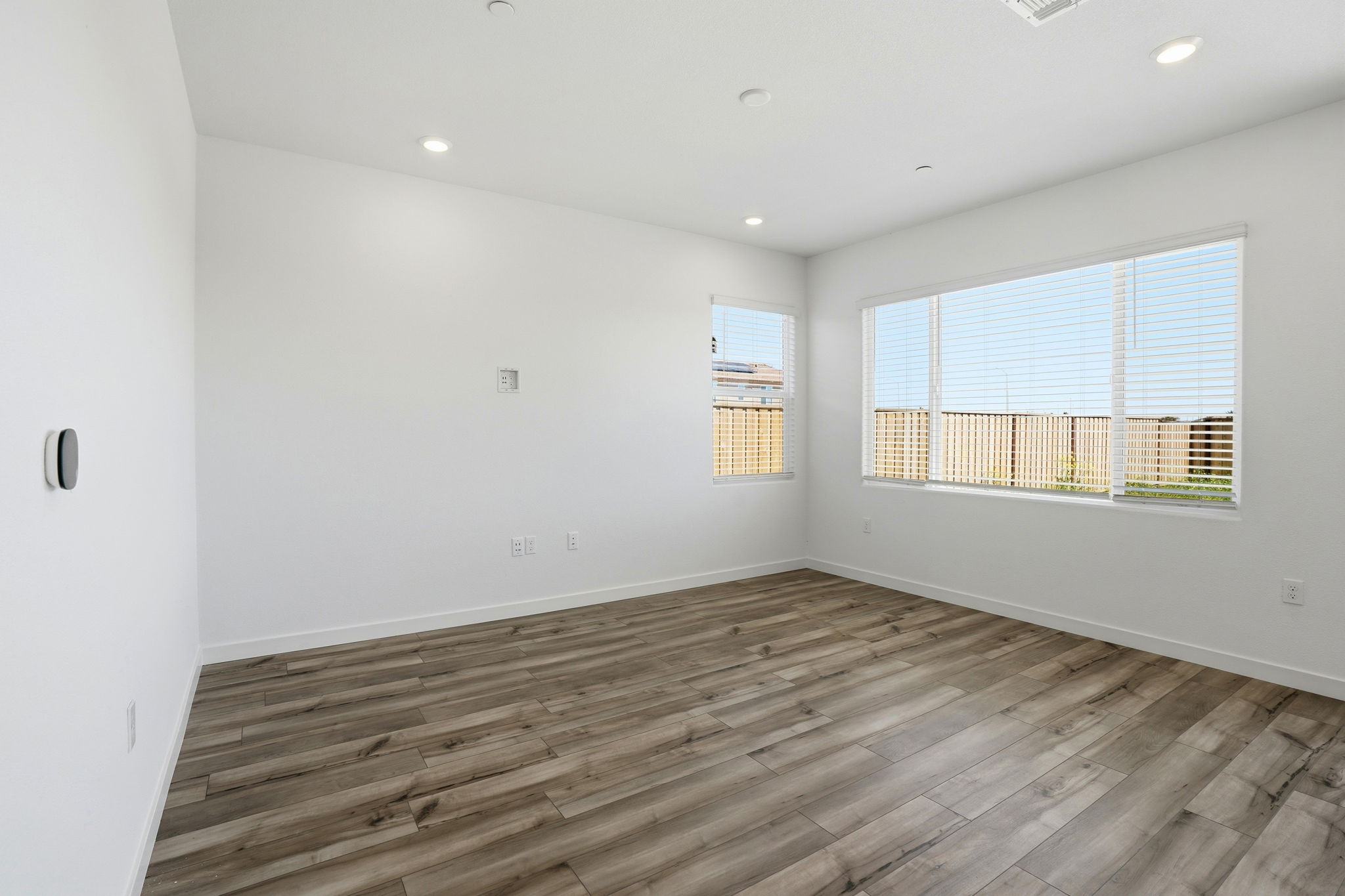 A room with a wood floor and windows.