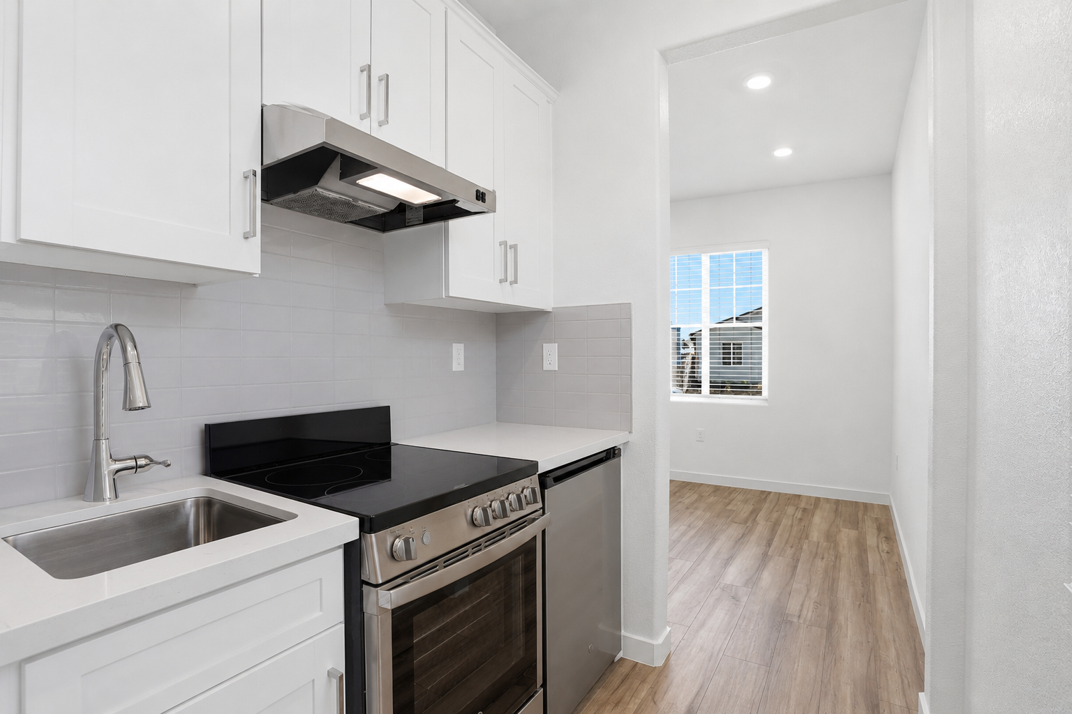 A kitchen with white cabinets.