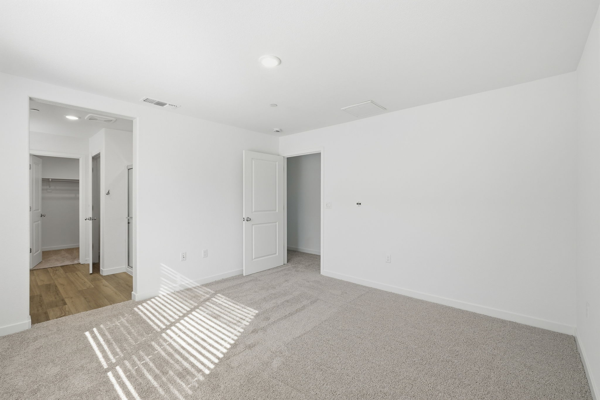 A long hallway with white doors.