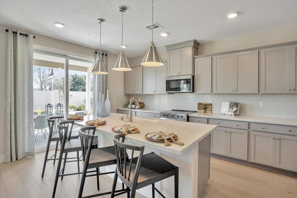 A kitchen with a table and chairs.