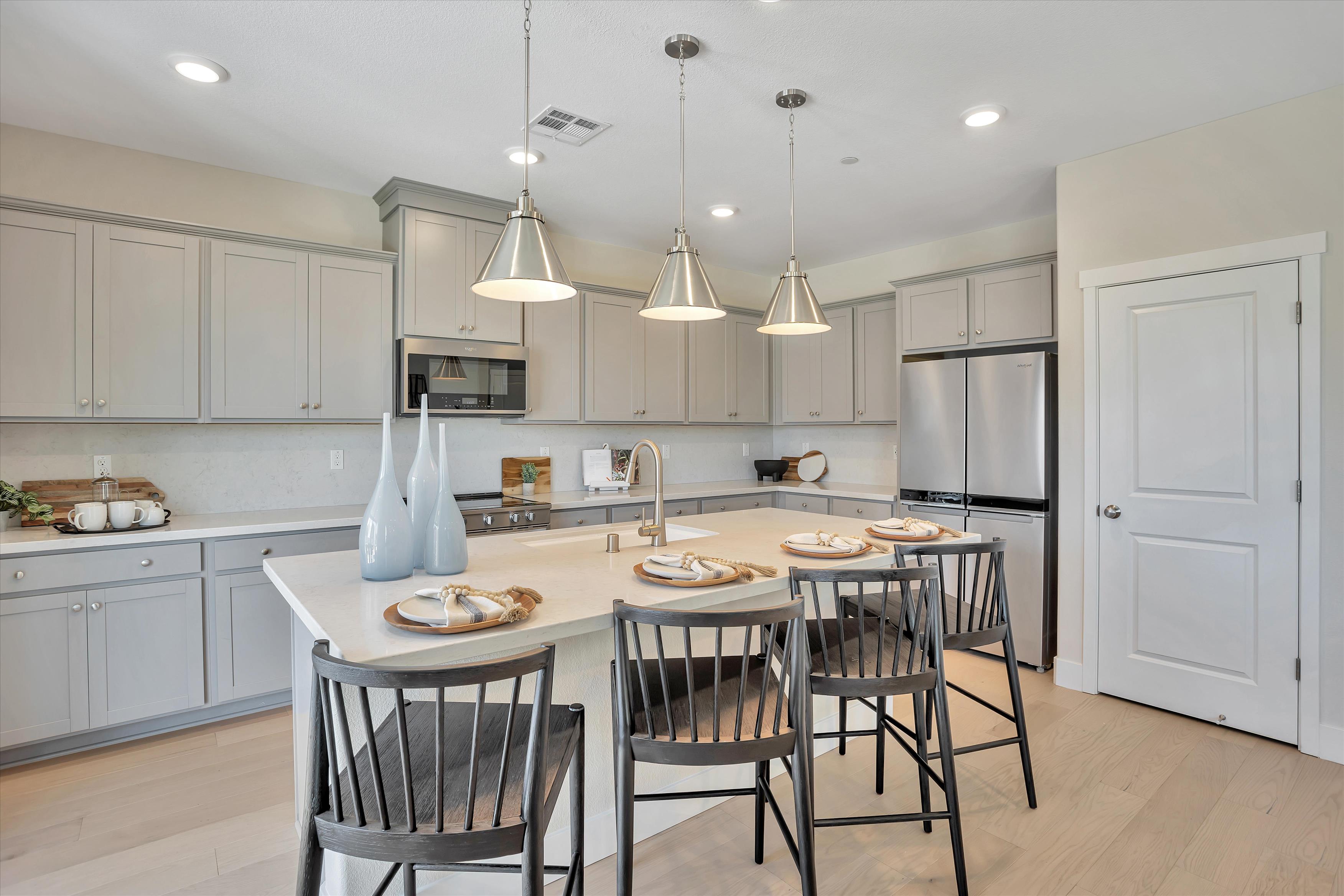 A kitchen with a table and chairs.