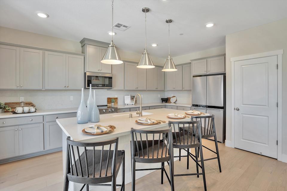 A kitchen with a table and chairs.