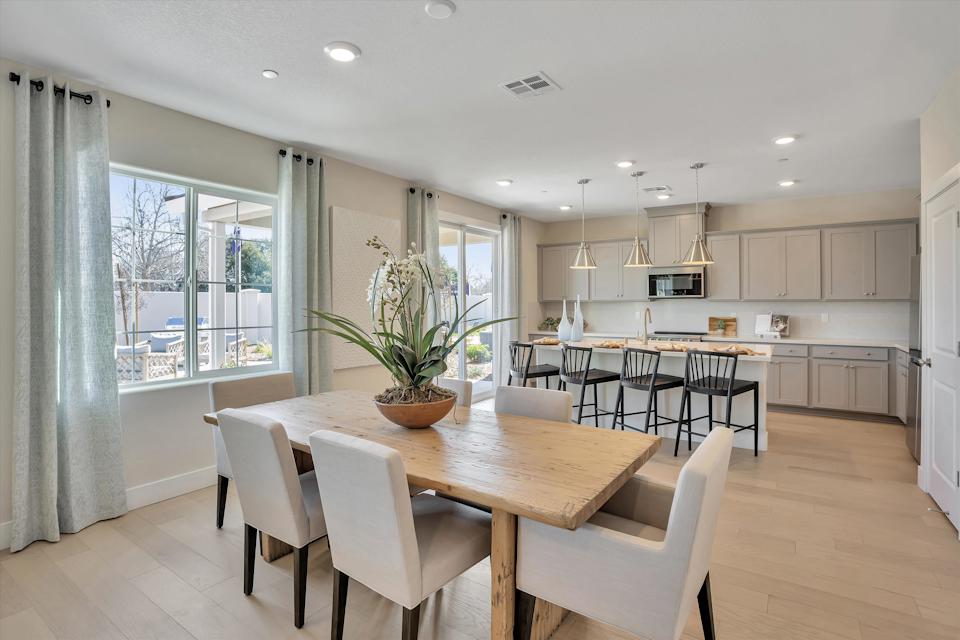 A kitchen with a dining table and chairs.