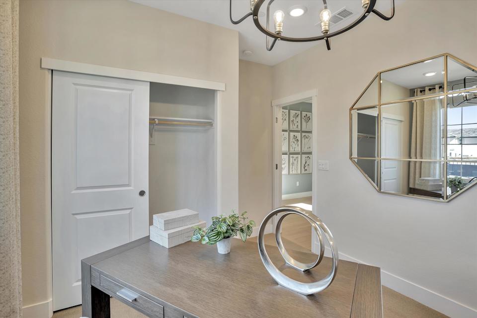 A room with a round table and a mirror.