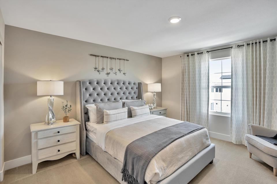 A bedroom with a bed and a chair.