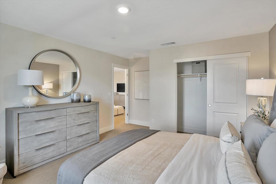 A bedroom with a bed and a mirror.