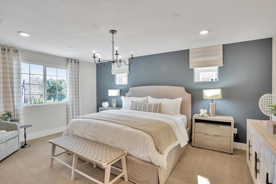 A bedroom with a bed and a bench.