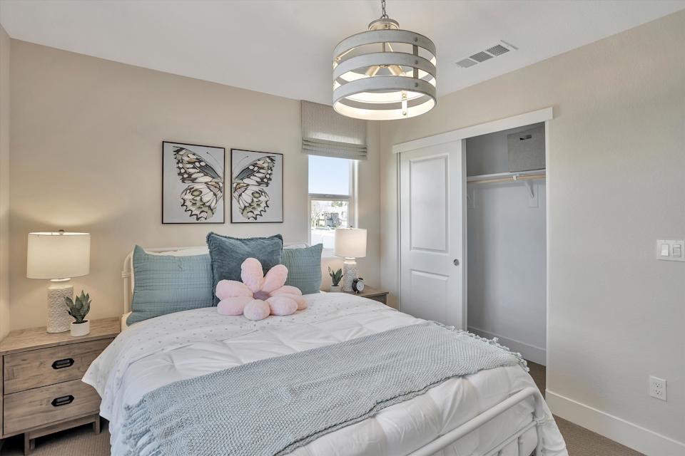 A bedroom with a bed and lamps.