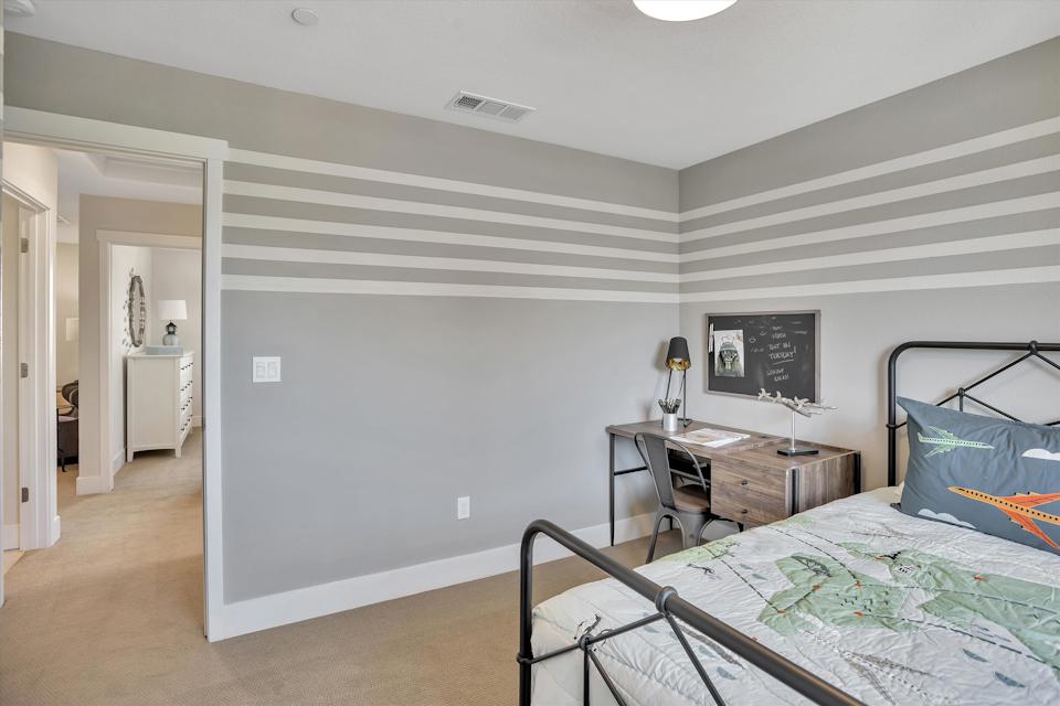 A bedroom with a bed desk and a tv.