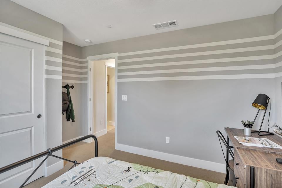 A bedroom with a bed and a desk.