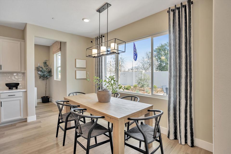 A dining room table with chairs and a chandelier.