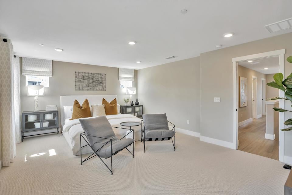 A room with a bed and chairs.