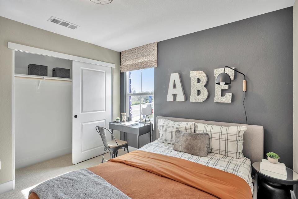 A bedroom with a bed and a chair.