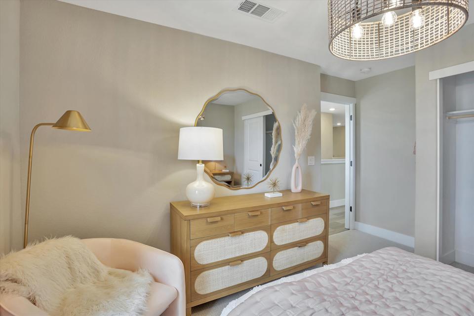 A bedroom with a mirror and a bed.