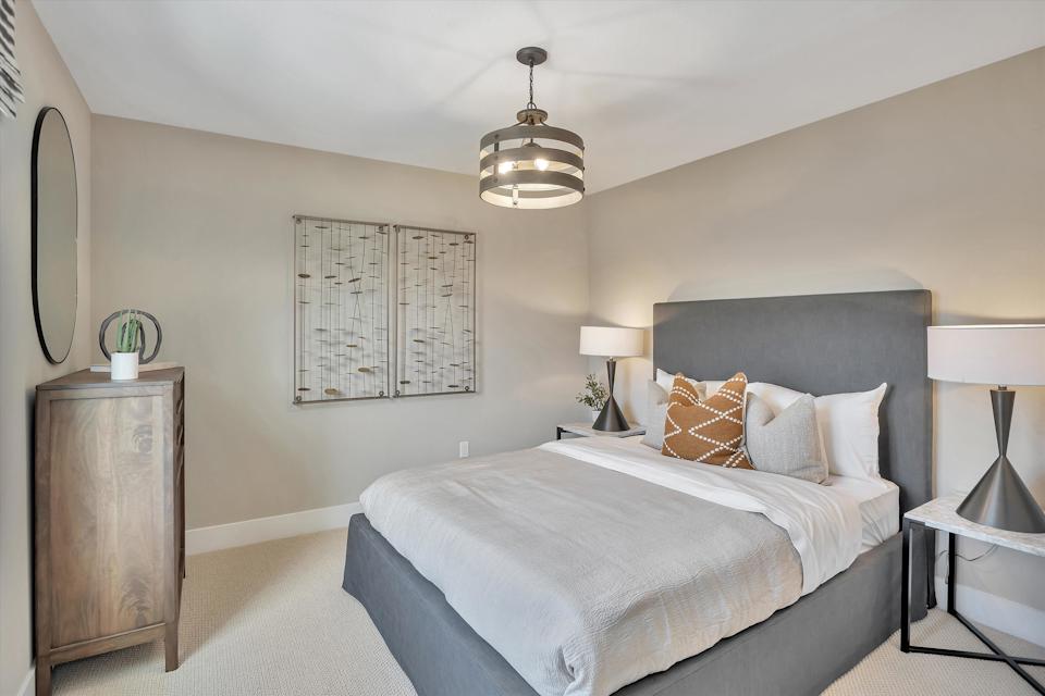 A bedroom with a bed and a lamp.