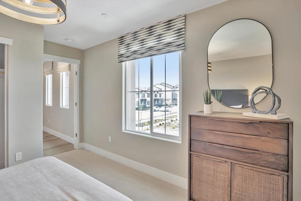 A room with a large mirror and a large window.