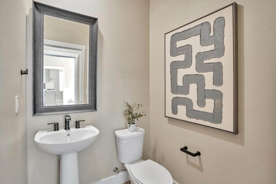 A bathroom with a picture on the wall.