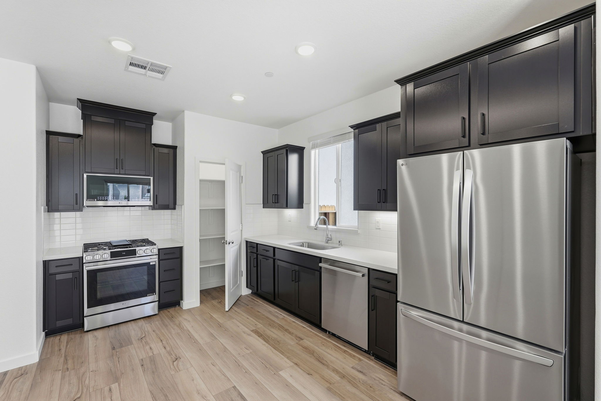 A kitchen with black cabinets.