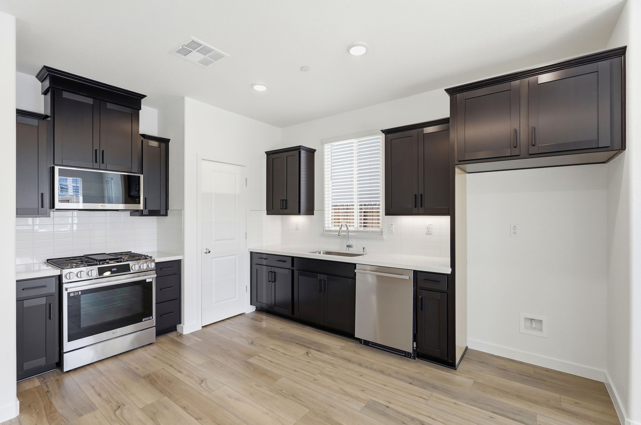 A kitchen with black cabinets.