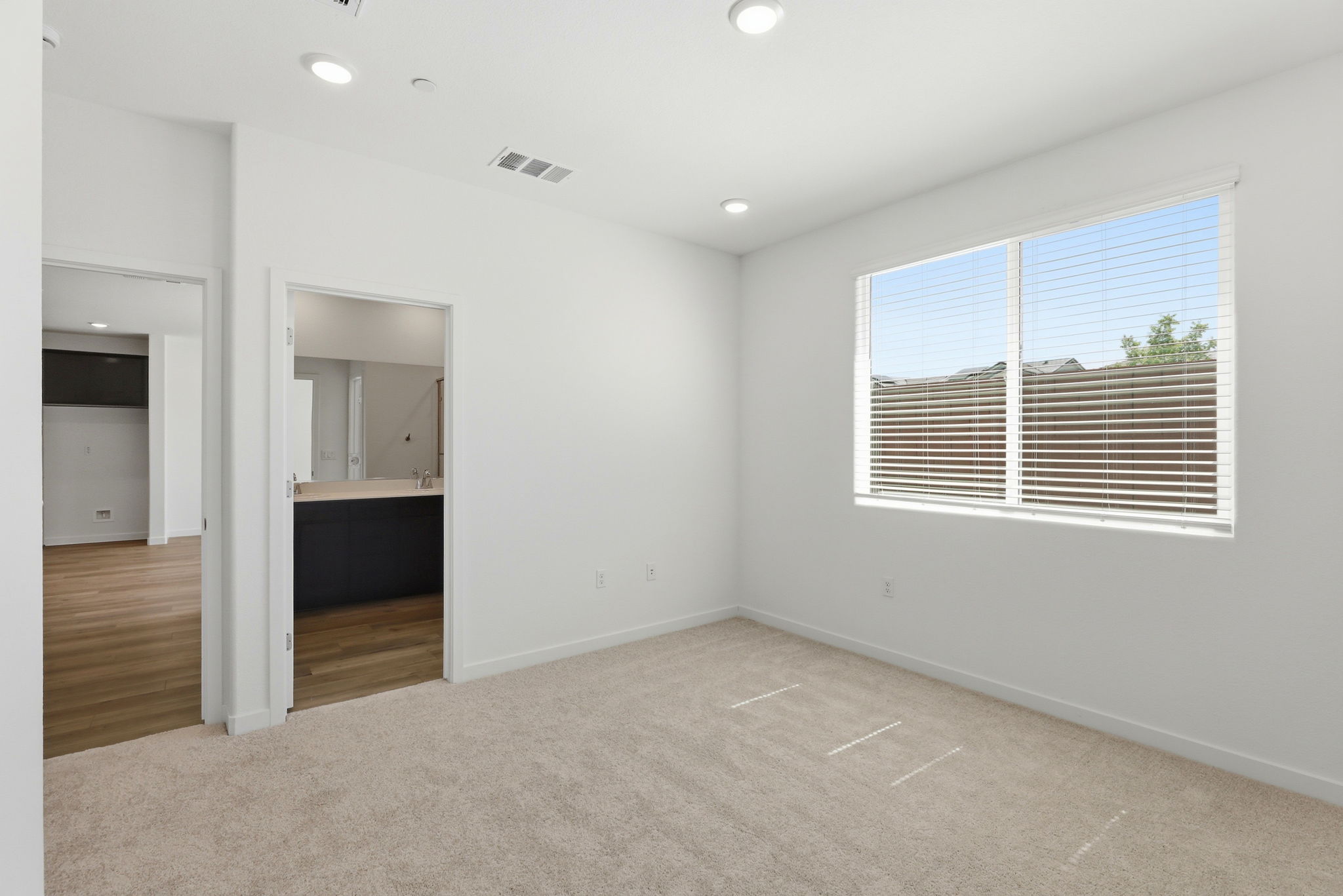 A room with a window and a bed.